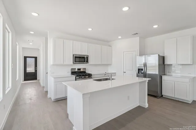 a kitchen with white cabinets and stainless steel appliances