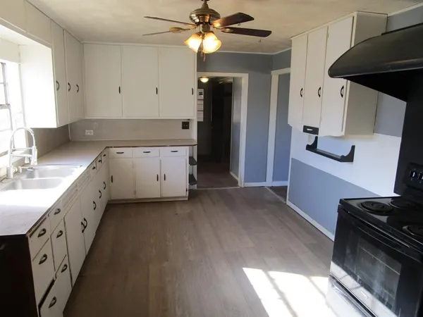 a kitchen with granite countertop white cabinets and sink