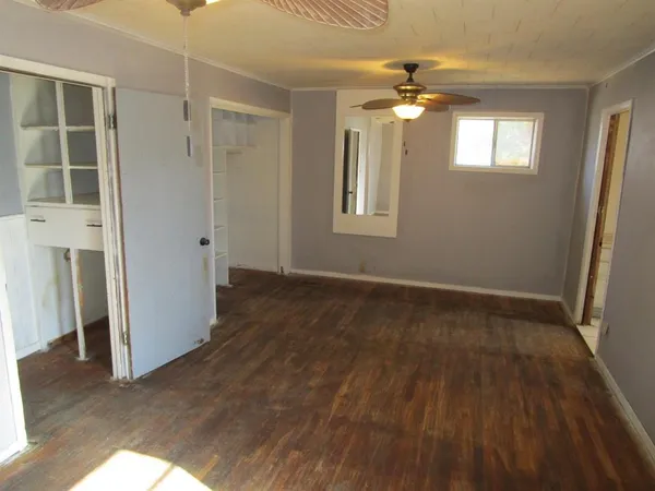 an empty room with wooden floor chandelier and closet area
