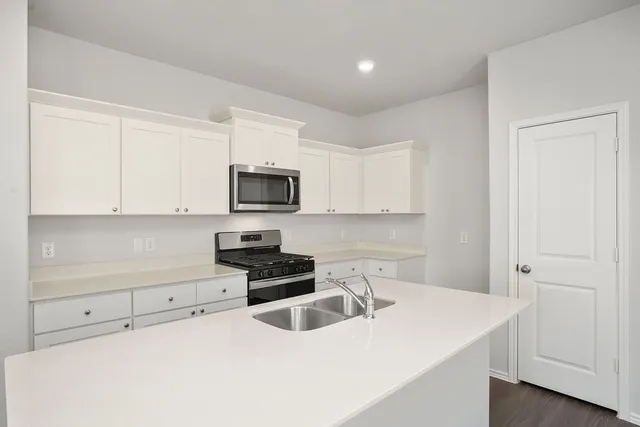 a kitchen with granite countertop white cabinets and white appliances