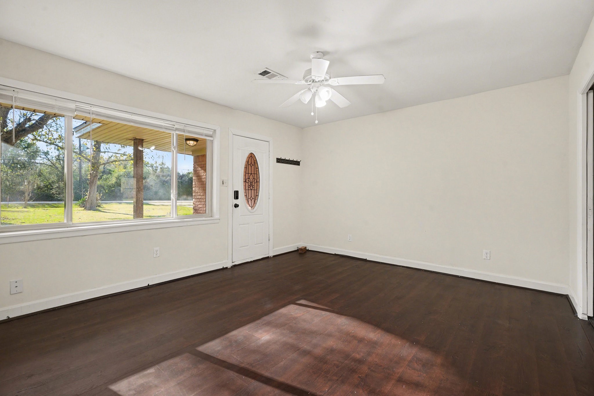4802 Crosby Cedar Bayou Road Baytown, TX 77521 - Photo 4 of 28 an empty room with wooden floor and windows