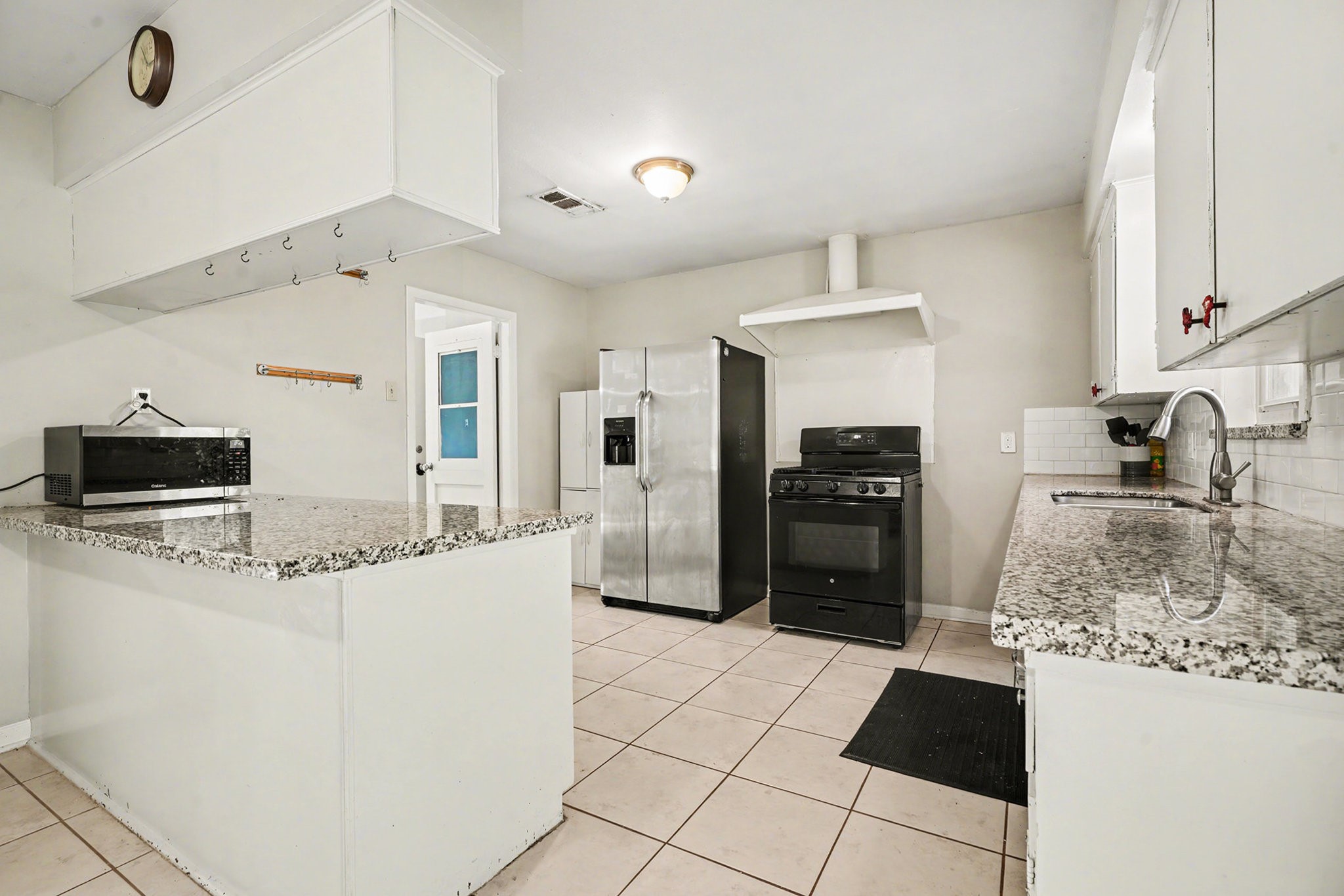 4802 Crosby Cedar Bayou Road Baytown, TX 77521 - Photo 10 of 28 a kitchen with granite countertop a refrigerator and a stove top oven