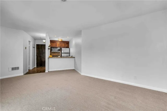 a view of a kitchen with a refrigerator and a sink