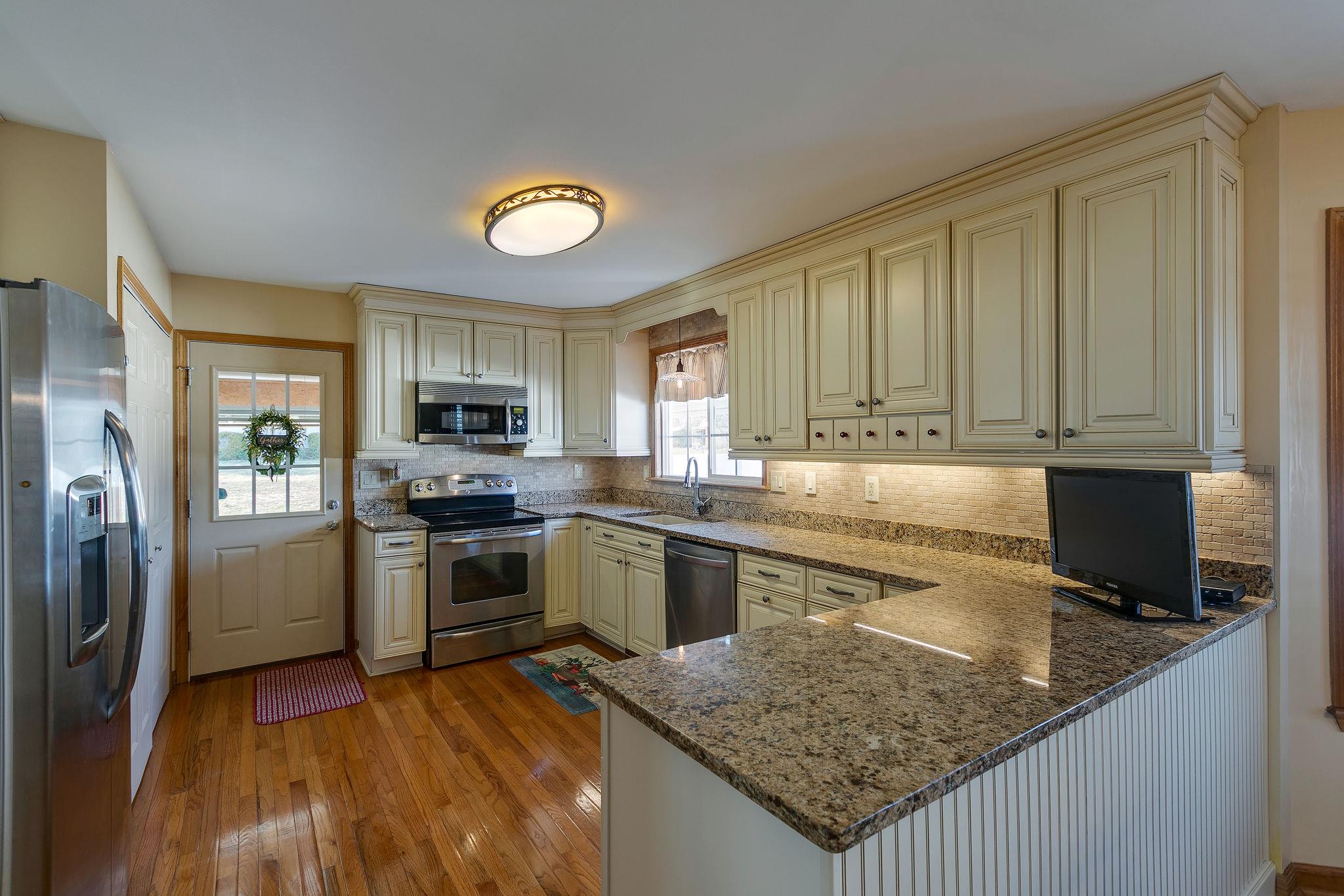 3467 Greens Mill Road Spring Hill, TN 37174 - Photo 17 of 28 a kitchen with stainless steel appliances granite countertop a stove top oven a sink and dishwasher