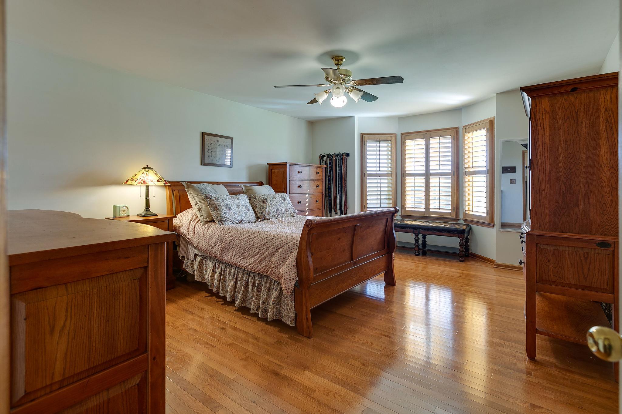 3467 Greens Mill Road Spring Hill, TN 37174 - Photo 8 of 28 a spacious bedroom with a bed windows and a chandelier