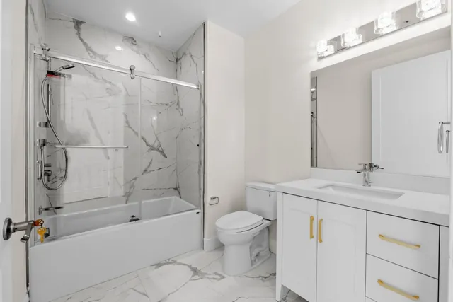 a large white kitchen with wooden floors and stainless steel appliances