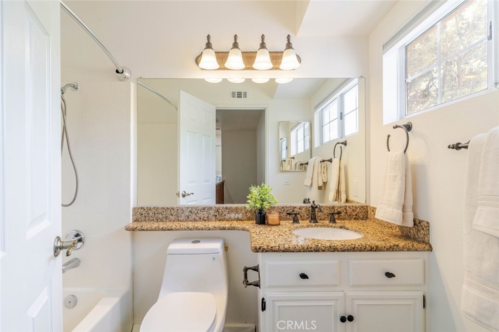 31256 Quail Valley Road Castaic, CA 91384 - Photo 18 of 31 a bathroom with a granite countertop sink a toilet and a mirror