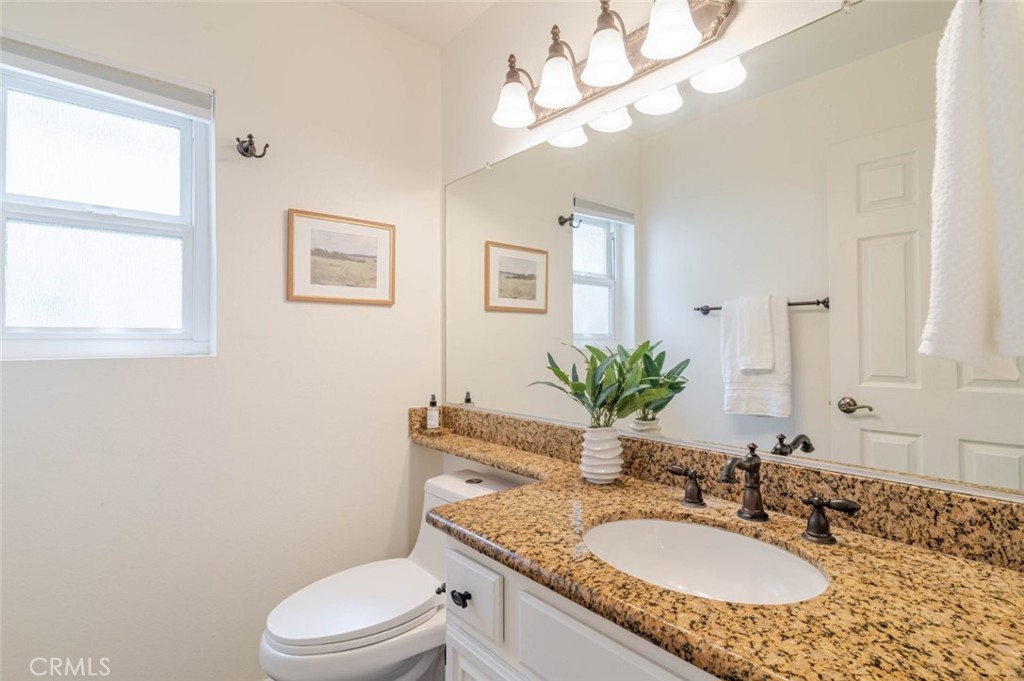 31256 Quail Valley Road Castaic, CA 91384 - Photo 19 of 31 a bathroom with a granite countertop toilet a sink and a mirror