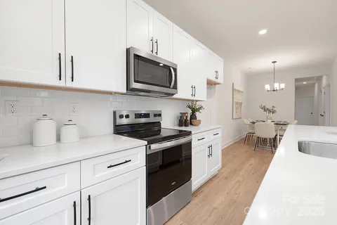 a kitchen with white cabinets stainless steel appliances and sink