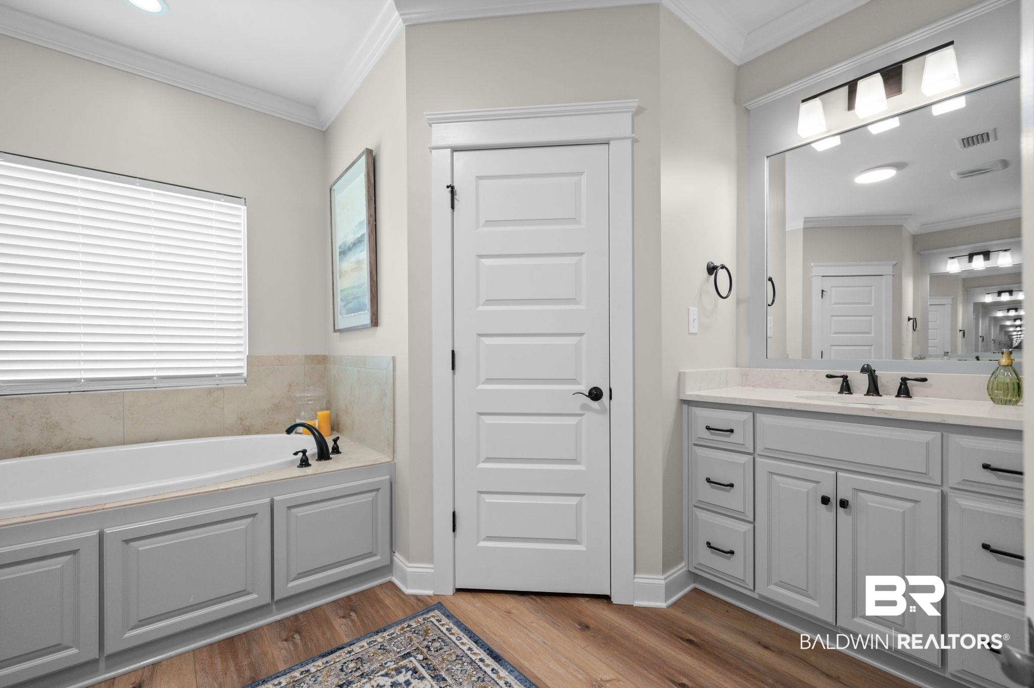 409 Fortune Drive Fairhope, AL 36532 - Photo 21 of 42 Bathroom featuring a built-in tub with tile surround, a single window with blinds, and wood-finish flooring