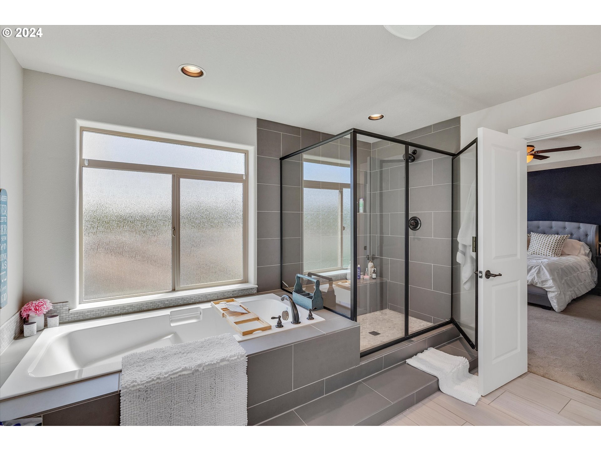 12934 Southwest Buckfield Lane Portland, OR 97224 - Photo 20 of 27 a bathroom with a tub mirror and glass door