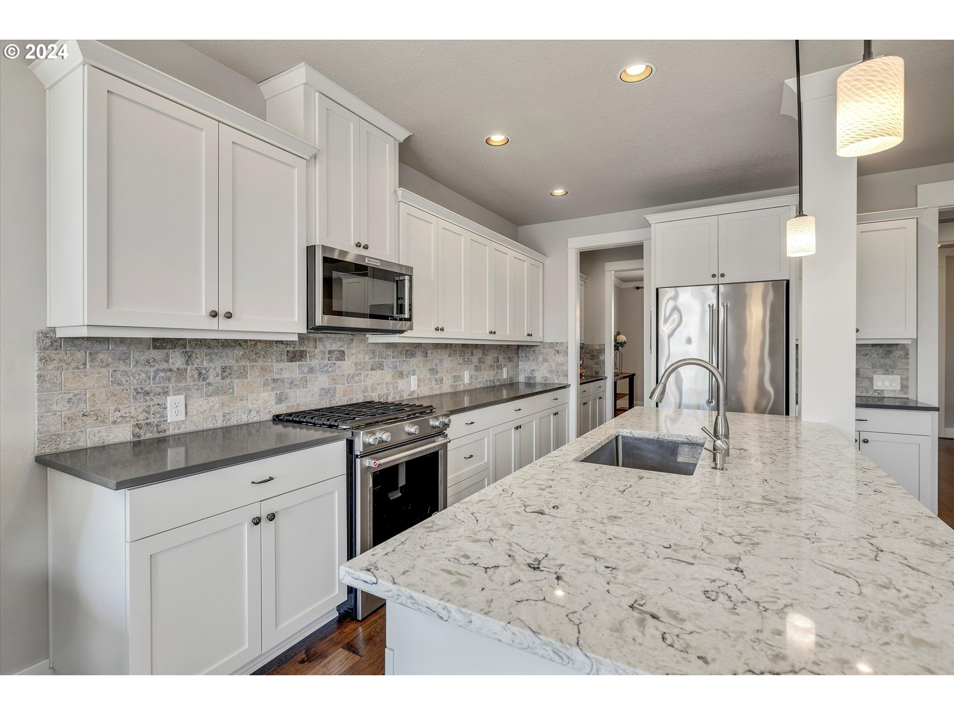12934 Southwest Buckfield Lane Portland, OR 97224 - Photo 6 of 27 a kitchen with stainless steel appliances granite countertop a stove top oven a sink a refrigerator and white cabinets
