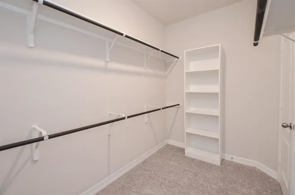 an empty room with a window and a chandelier fan