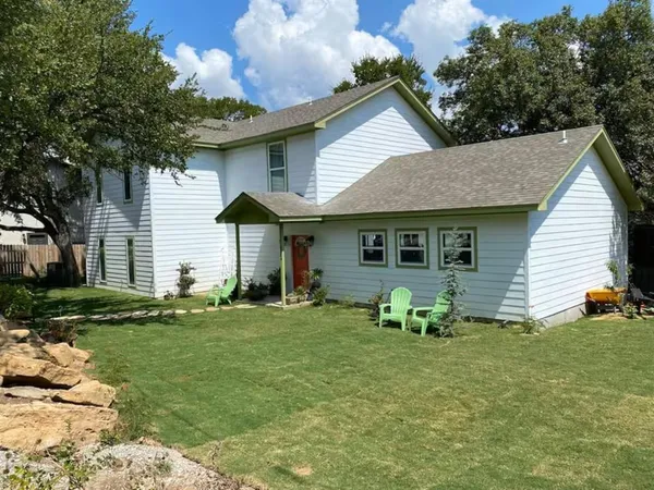 a backyard of a house with table and chairs