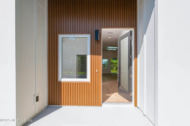 a view of a porch with a door and wooden floor