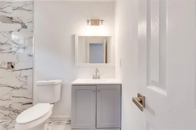 a bathroom with a toilet a sink and mirror
