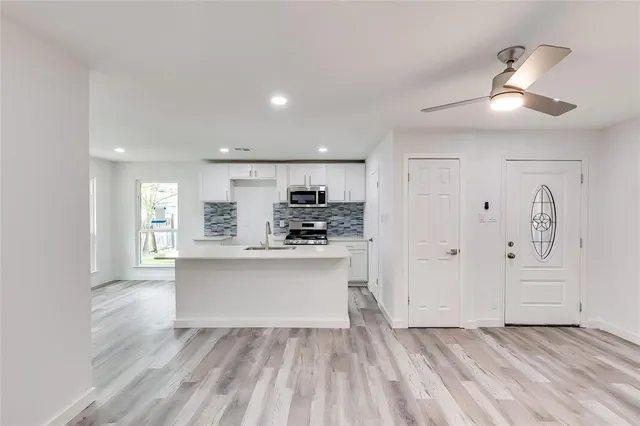 a view of kitchen with sink and refrigerator
