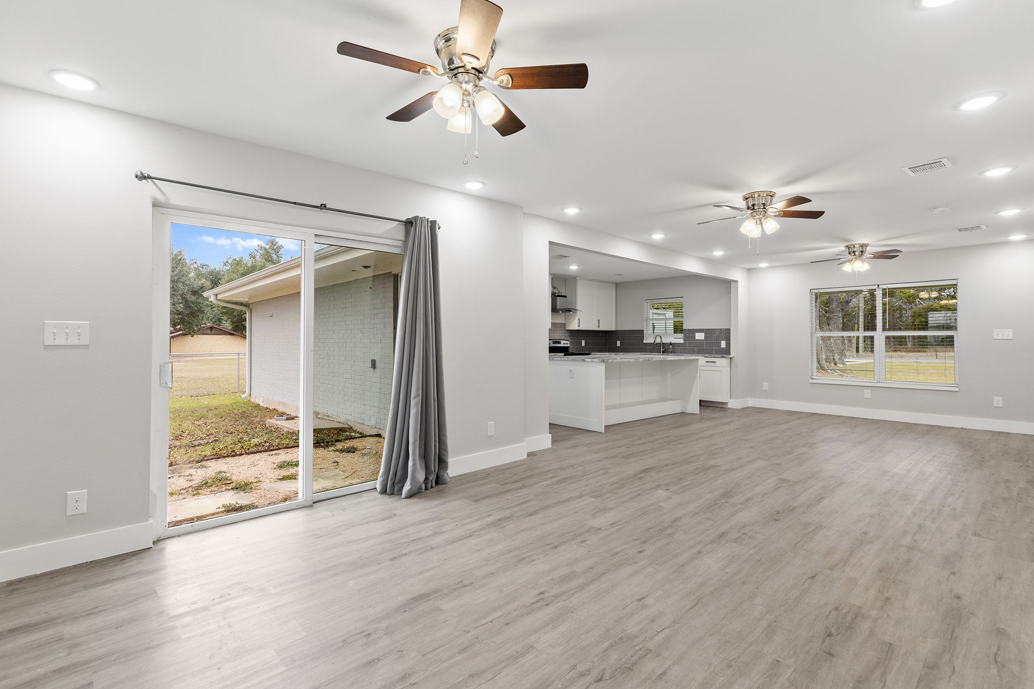 813 Central Avenue Elgin, TX 78621 - Photo 10 of 22 Unfurnished living room with a ceiling fan, recessed lighting, and light wood-style flooring