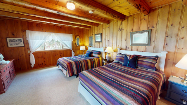 315 Abbey Road Moab, UT 84532 - Photo 8 of 46 Bedroom with light colored carpet, wooden walls, a wooden ceiling with exposed beams, and electric panel