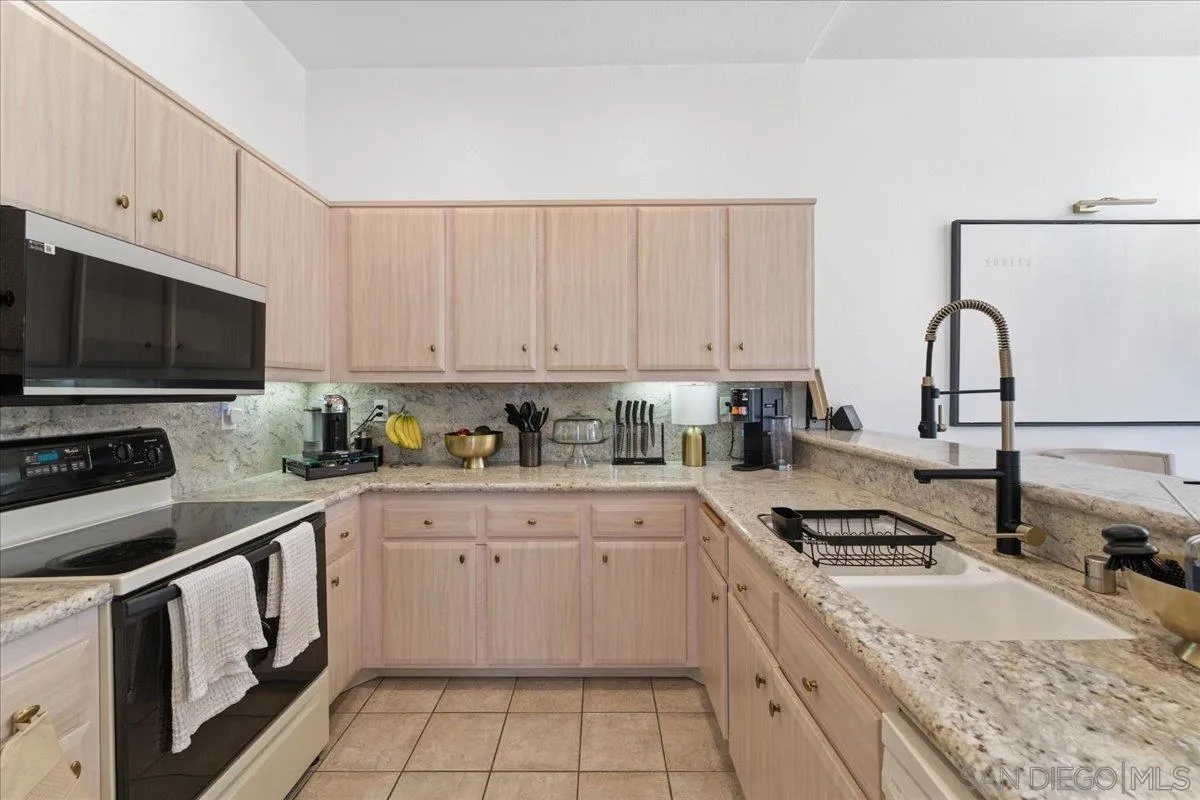 29585 Circle R Greens Drive Escondido, CA 92026 - Photo 6 of 40 a kitchen with granite countertop a sink a stove and cabinets