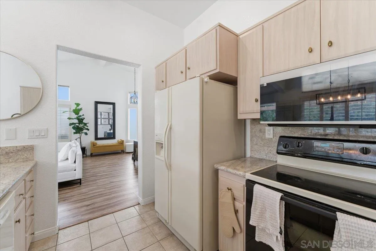 29585 Circle R Greens Drive Escondido, CA 92026 - Photo 8 of 40 a kitchen with stainless steel appliances a refrigerator a stove and white cabinets