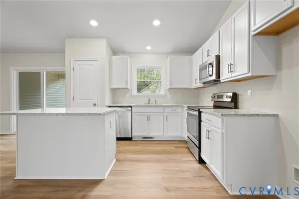 a kitchen with granite countertop white cabinets and white appliances