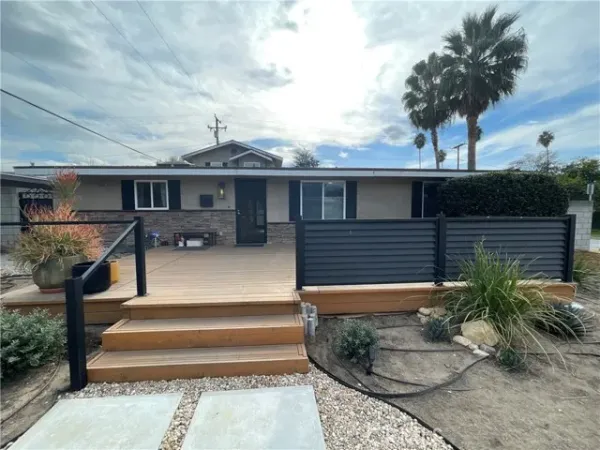 a front view of a house with garden and plants