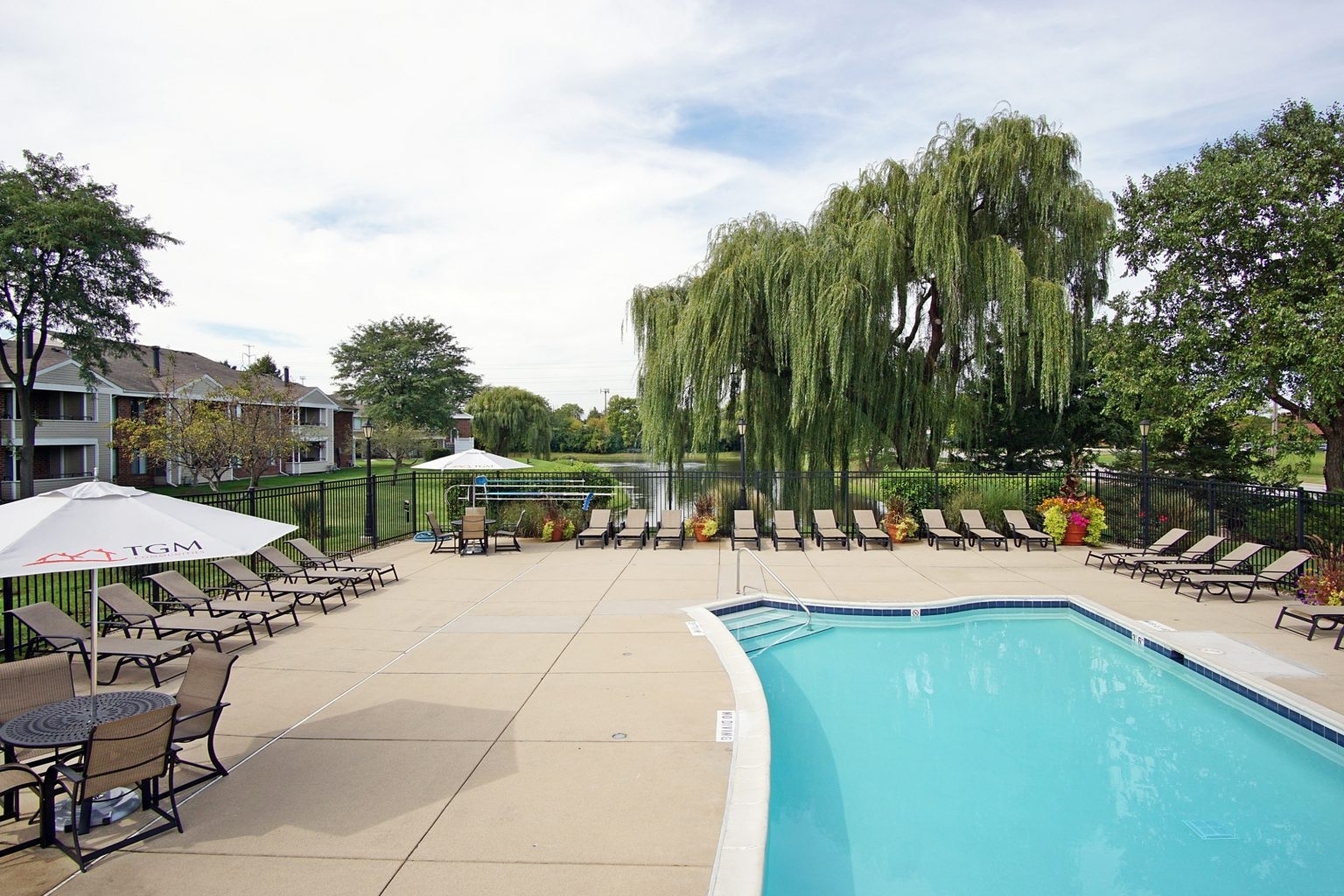 1637 Westminster Drive, Unit 112 Naperville, IL 60563 - Photo 11 of 53 a view of a swimming pool with a table and chairs under an umbrella