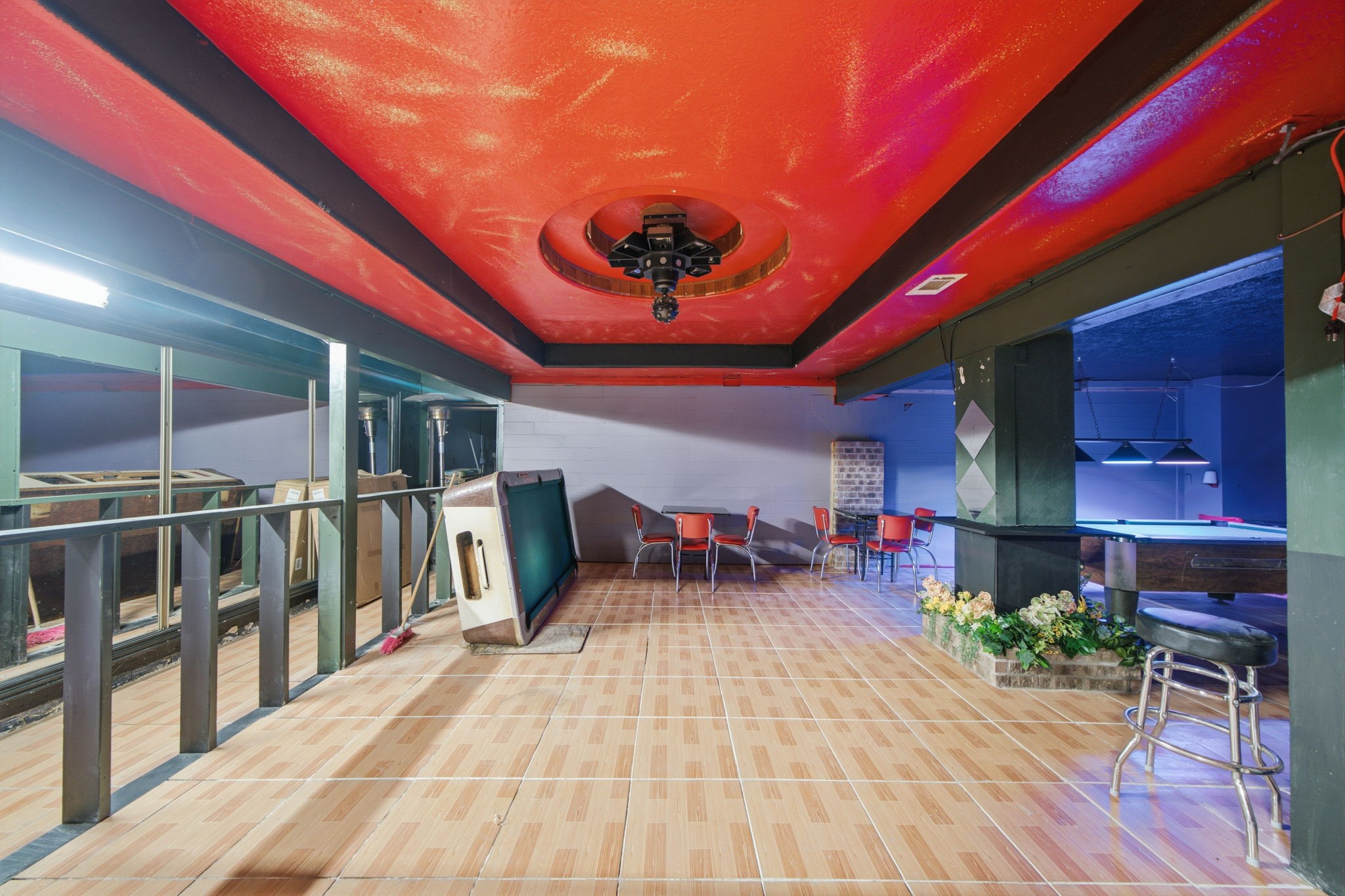 7715 West Hardy Road Houston, TX 77022 - Photo 12 of 19 Discover a spacious entertainment area featuring a vibrant red ceiling, stylish bar seating, and a pool table, perfect for hosting gatherings and enjoying leisure activities.