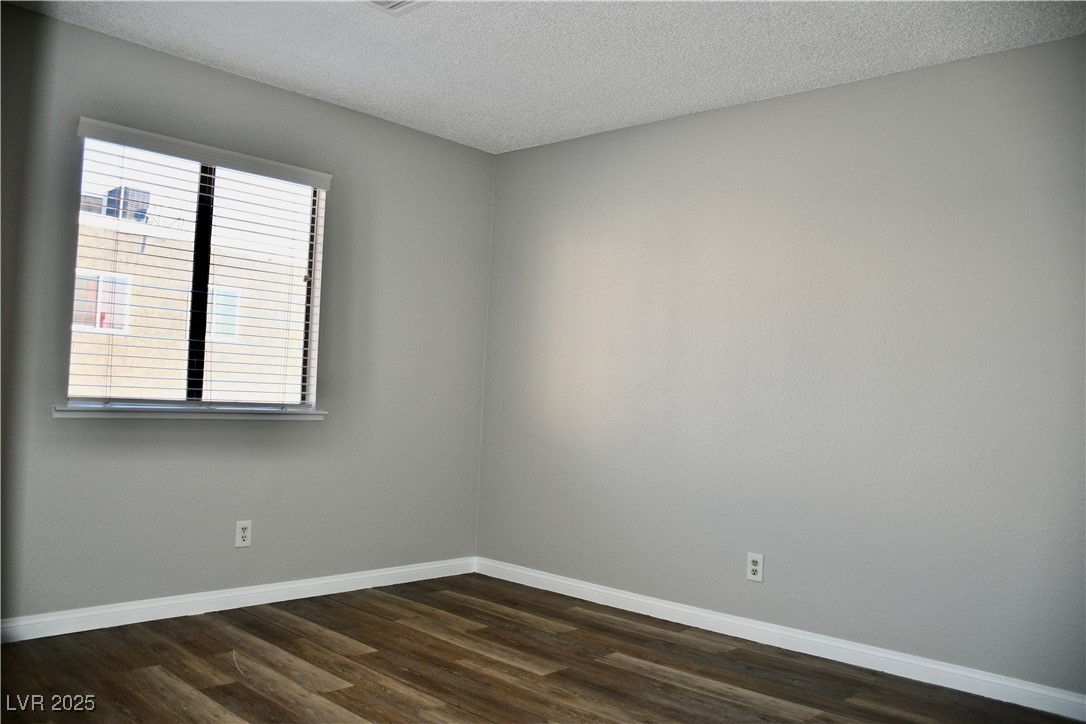 6925 Hopkins Drive, Unit 3 Las Vegas, NV 89156 - Photo 11 of 12 Unfurnished room featuring a textured ceiling and dark wood-style floors