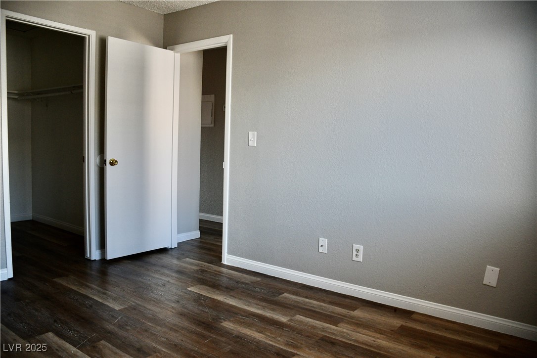 6925 Hopkins Drive, Unit 3 Las Vegas, NV 89156 - Photo 7 of 12 Unfurnished bedroom with dark wood-style floors and a spacious closet