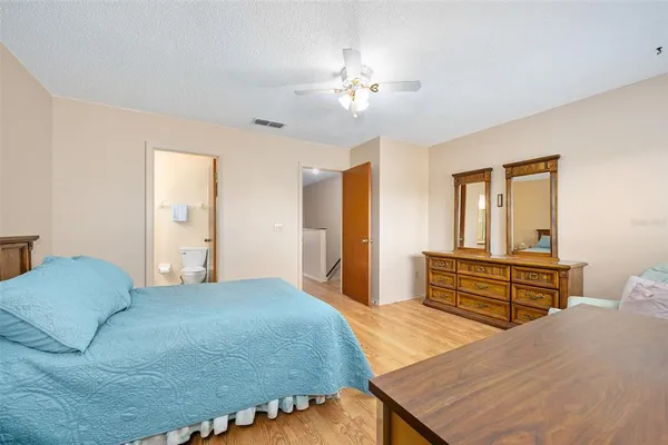 a bedroom with a bed and dresser with mirror