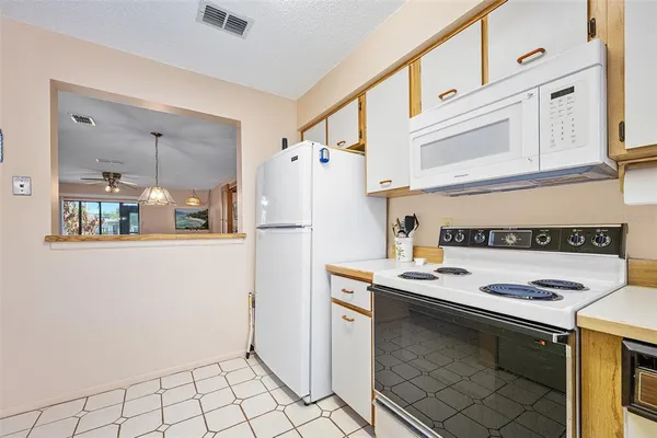 a kitchen with refrigerator and cabinets