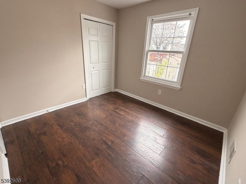 139 Inslee Place, Unit 1 Elizabeth Port, NJ 07206 - Photo 11 of 18 an empty room with wooden floor and windows