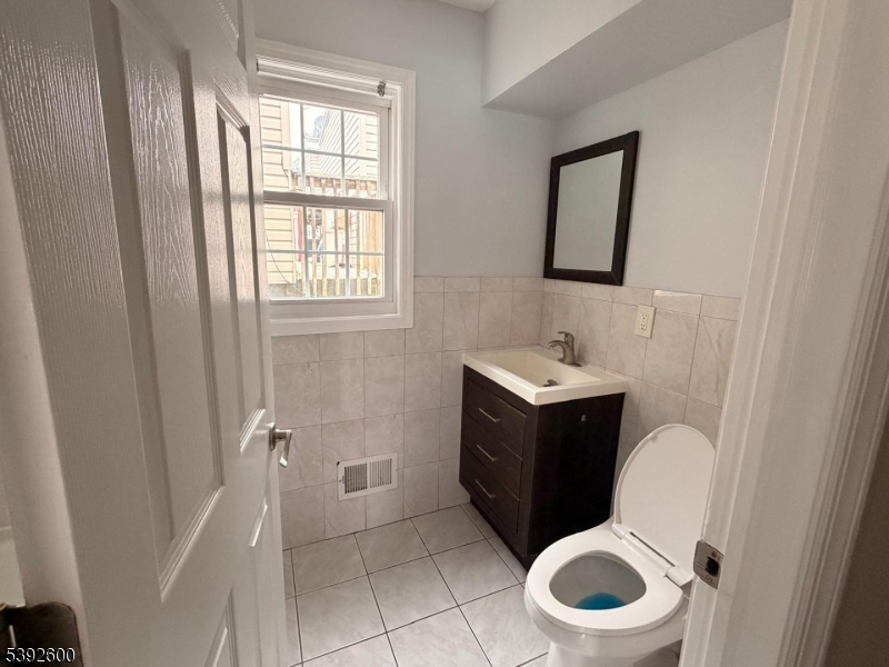 139 Inslee Place, Unit 1 Elizabeth Port, NJ 07206 - Photo 14 of 18 a bathroom with a toilet sink and mirror