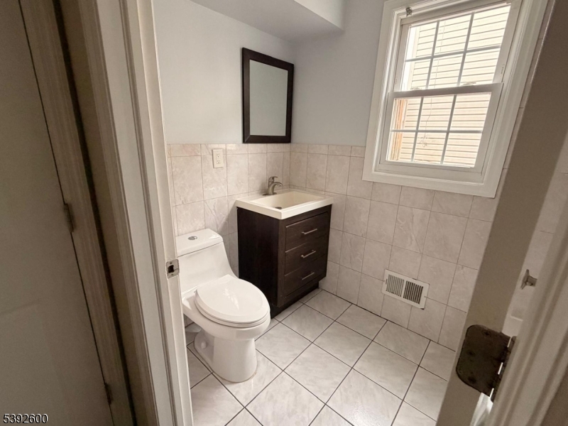 139 Inslee Place, Unit 1 Elizabeth Port, NJ 07206 - Photo 16 of 18 a bathroom with a sink toilet and window