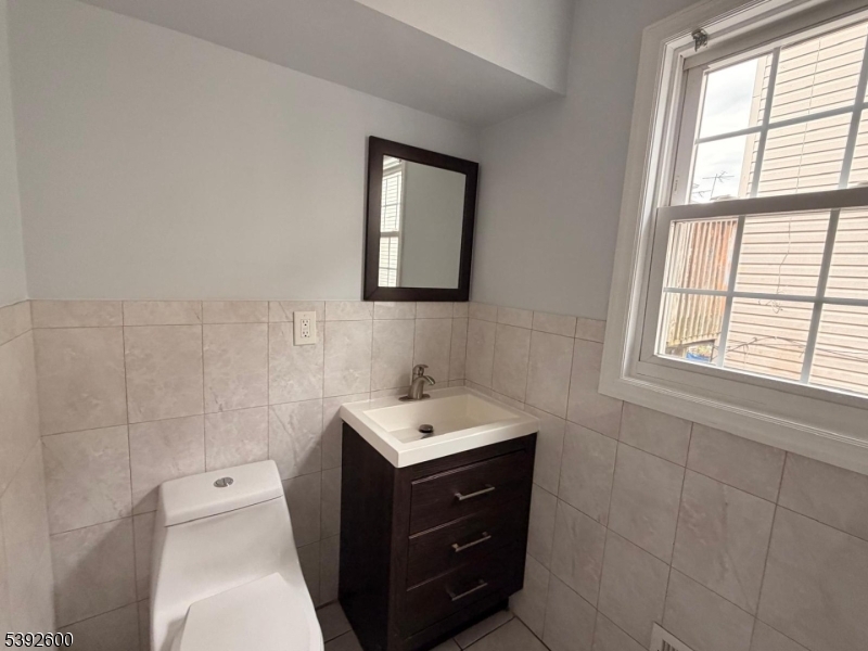 139 Inslee Place, Unit 1 Elizabeth Port, NJ 07206 - Photo 17 of 18 a bathroom with a sink vanity and a mirror