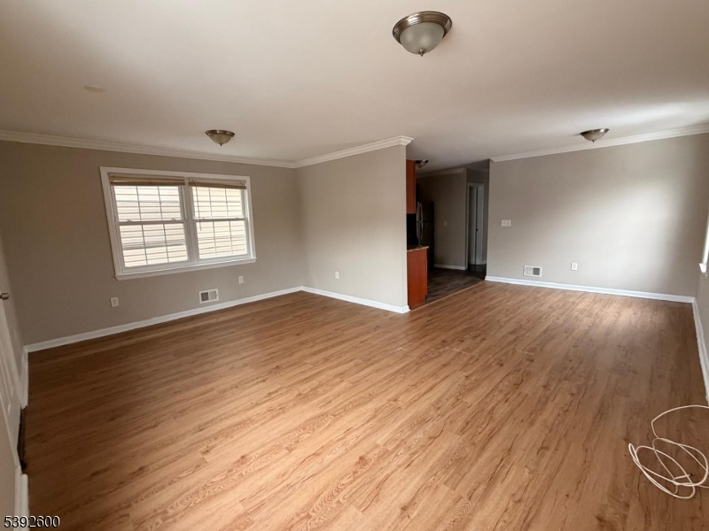 139 Inslee Place, Unit 1 Elizabeth Port, NJ 07206 - Photo 4 of 18 an empty room with wooden floor and windows