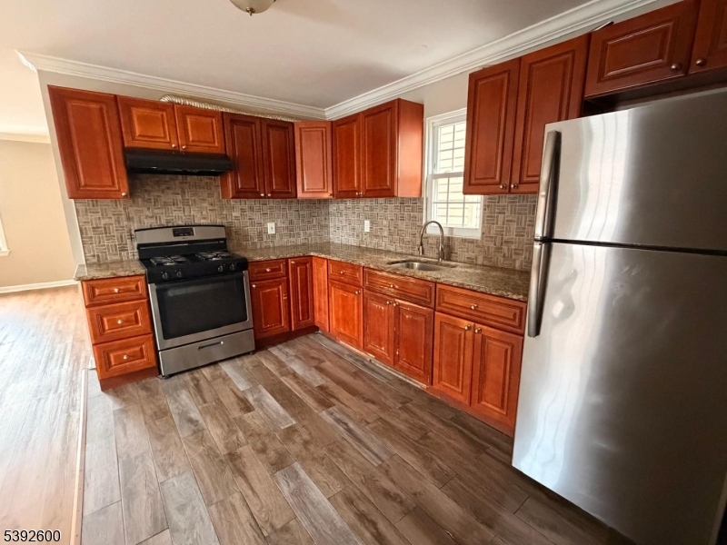 139 Inslee Place, Unit 1 Elizabeth Port, NJ 07206 - Photo 8 of 18 a kitchen with stainless steel appliances granite countertop a refrigerator a sink dishwasher a stove top oven a refrigerator and cabinets with wooden floor