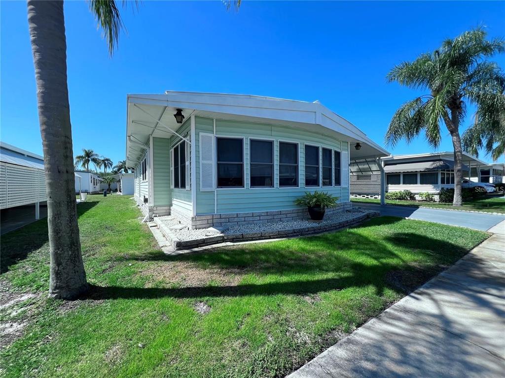 1100 South Belcher Road, Unit 772 Largo, FL 33771 - Photo 2 of 84 a front view of a house with a yard and potted plants