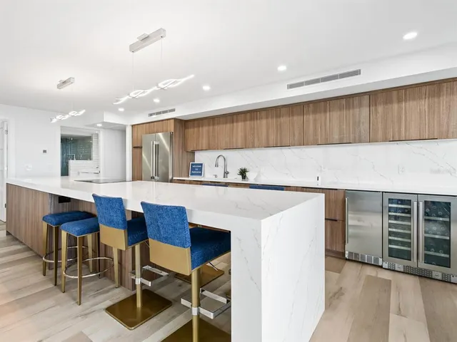 a large kitchen with stainless steel appliances a sink and counter