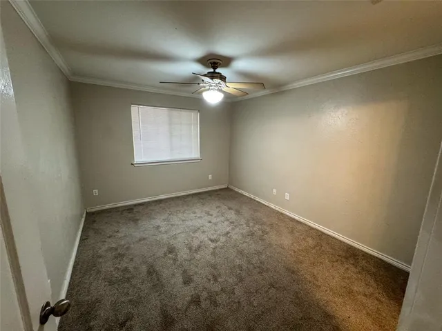 en empty room with ceiling fan and window