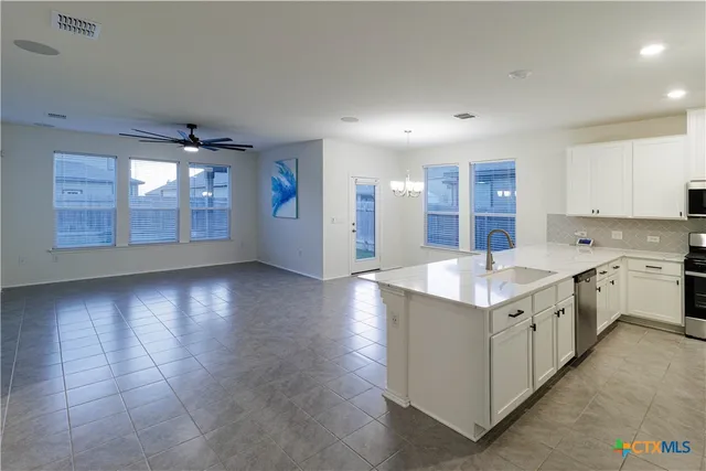a view of a kitchen with kitchen island stainless steel appliances refrigerator stove microwave and cabinets