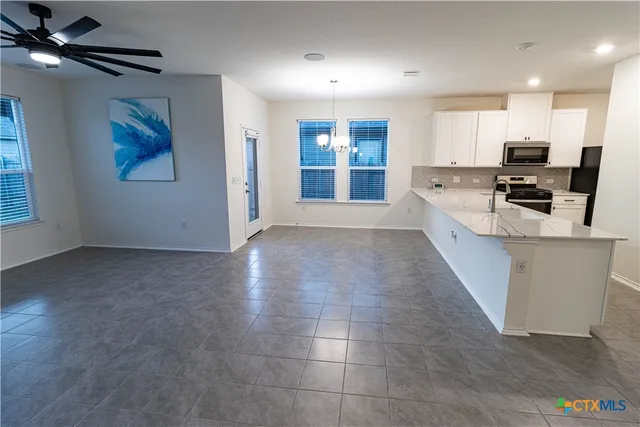 a view of a kitchen with a sink and a ceiling fan