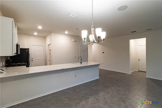 a large white kitchen with a chandelier