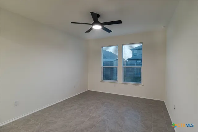 an empty room with closet and a ceiling fan