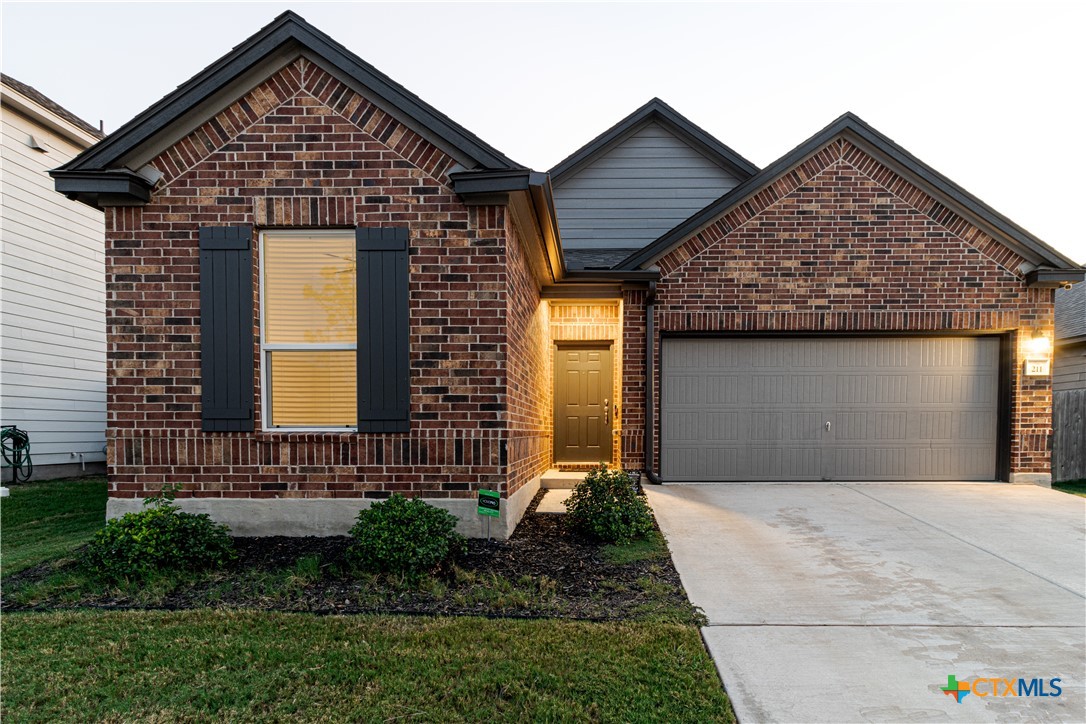 211 Summit Drive Lockhart, TX 78644 - Photo 2 of 33 a front view of a house with a yard and garage