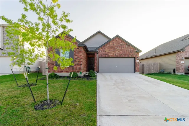 a front view of a house with a yard and trees