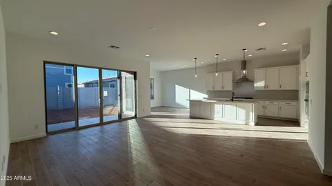 a view of a kitchen with large stainless steel appliances wooden floor and a large window