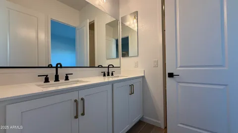 a bathroom with a double vanity sink and mirror